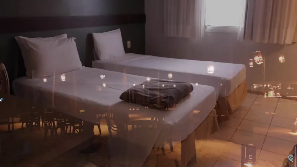 Quarto standard com duas camas de solteiro e iluminação aconchegante.