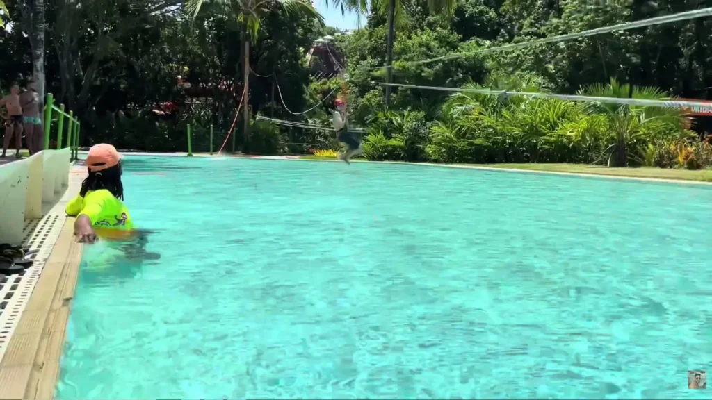 Criança descendo de tirolesa e caindo na piscina no Eco Parque Arraial d'Ajuda, Porto Seguro.