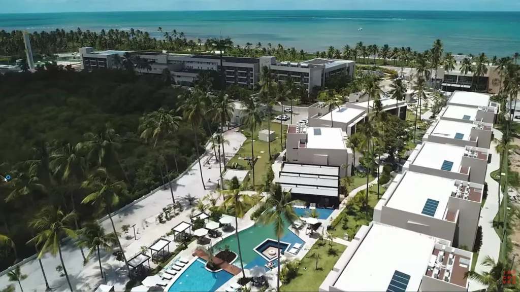 Vista aérea do Japaratinga Lounge Resort com piscinas e frente para o mar em Alagoas.