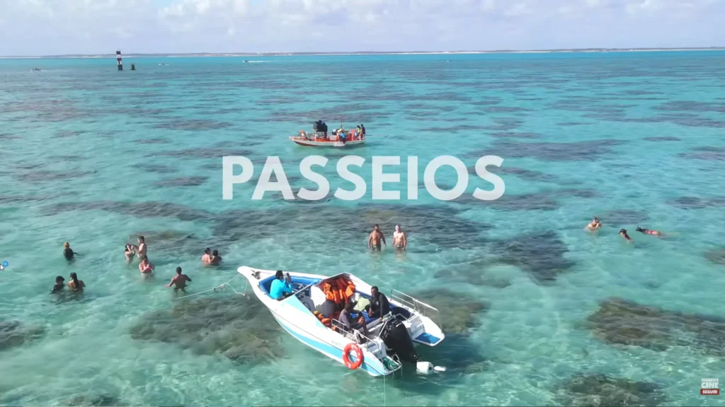 Barcos de passeio em águas cristalinas turquesa com turistas nas piscinas naturais próximas ao Ocean Palace Natal.