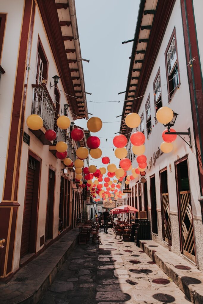 Rua de pedra decorada com balões coloridos entre casarões coloniais em Diamantina, Minas Gerais, um cenário festivo para viagens culturais brasil.