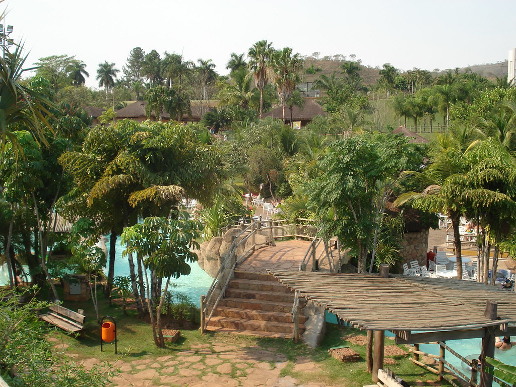 Área de piscinas naturais e pontes de madeira cercadas por palmeiras no Hot Park em Rio Quente.