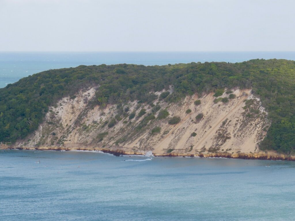 Vista icônica do Morro do Careca em Natal com sua duna de areia e vegetação lateral descendo até o mar.