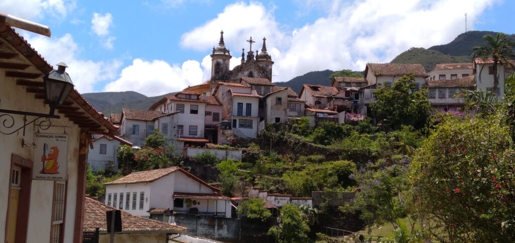 Ladeiras de pedra e casarões coloniais preservados em Ouro Preto, Minas Gerais, com a Igreja de Santa Efigênia no topo, um cenário clássico de viagens culturais brasil.