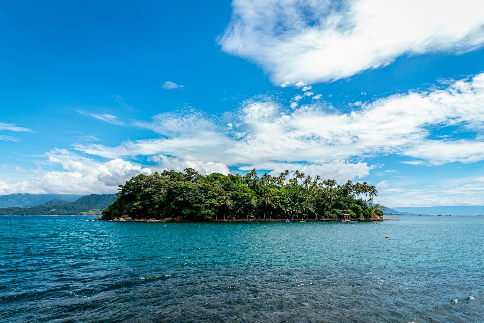 Paisagem da Ilha das Cabras cercada por mar azul, um dos pontos turísticos mais visitados por quem faz viagens para o litoral de São Paulo.