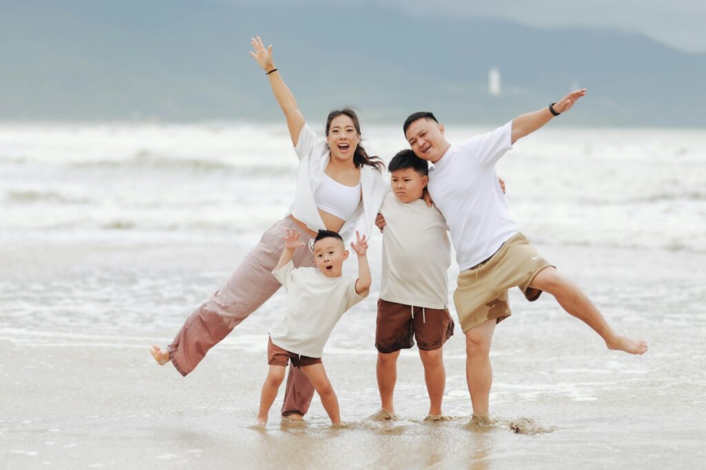 Família feliz posando na praia durante roteiros de férias familiares no litoral brasileiro.