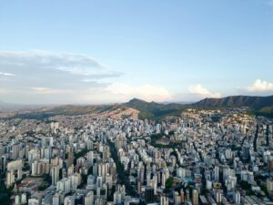 Vista aérea deslumbrante do horizonte de Belo Horizonte com colinas onduladas ao fundo, ao entardecer.