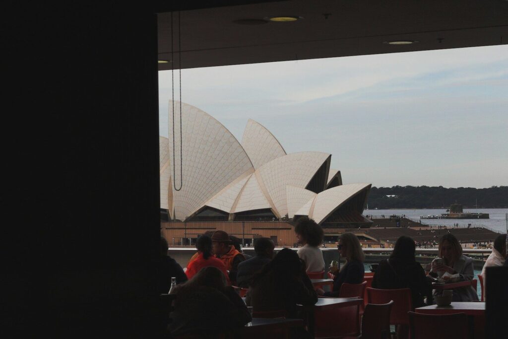 a group of people sitting at a table looking out at a large building