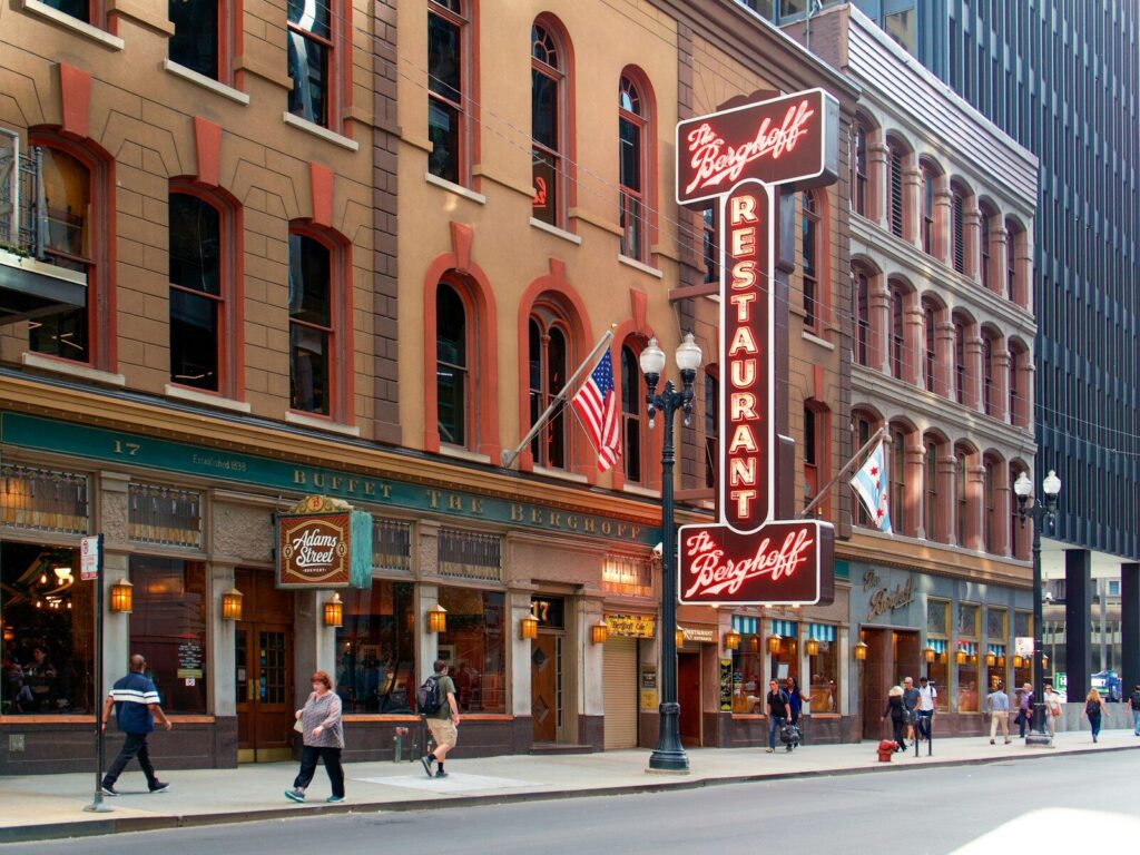 Pessoas caminhando na rua do restaurante Borgkeff durante o dia.