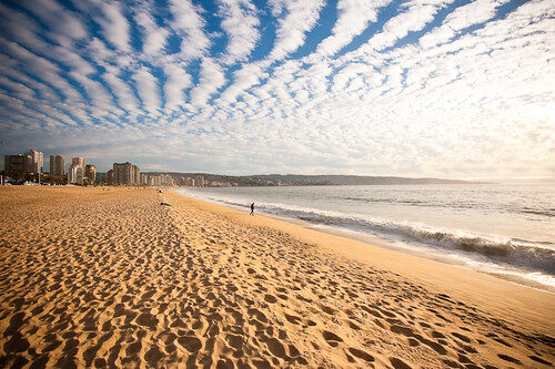 Praia urbana, céu ondulado, areia
