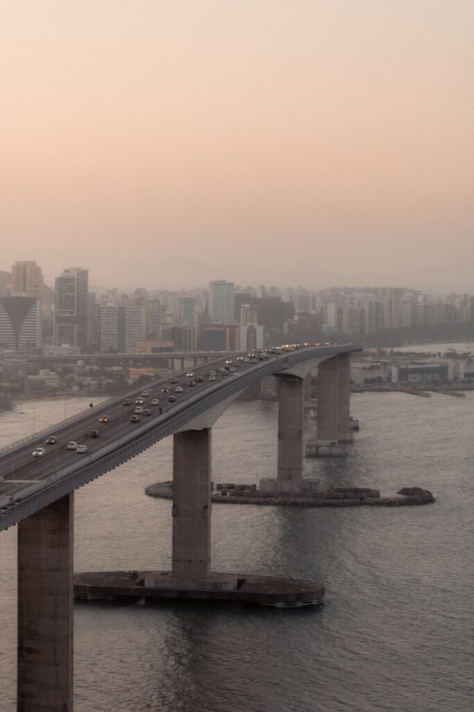 Aerial view of the Rio-Niterói Bridge in Rio de Janeiro at sunset with cityscape background.