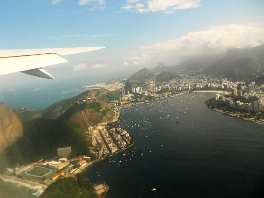 Airplane wing over a city bay filled with boats.