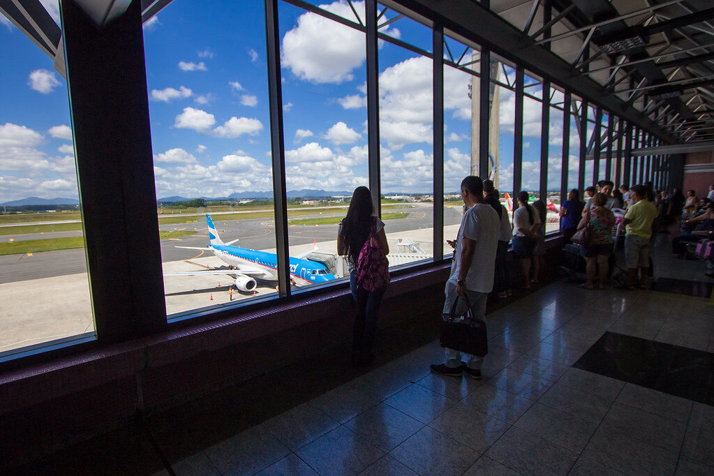 Pessoas observam avião no aeroporto