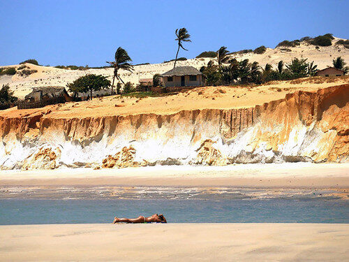 Pessoa na praia com falésias