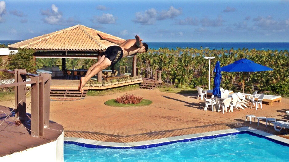 Homem mergulhando piscina tropical