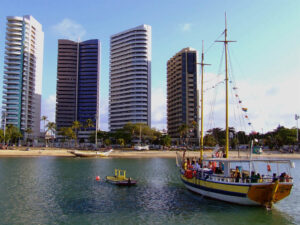 Barco turístico, praia, edifícios.
