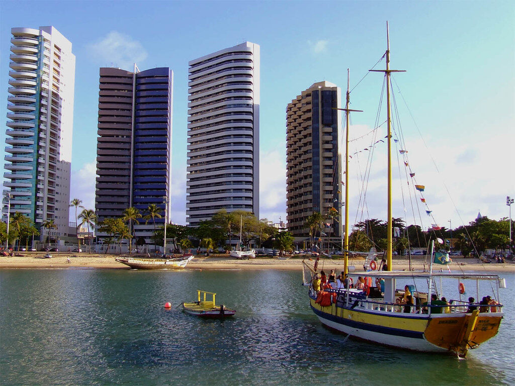 Barco turístico, praia, edifícios.