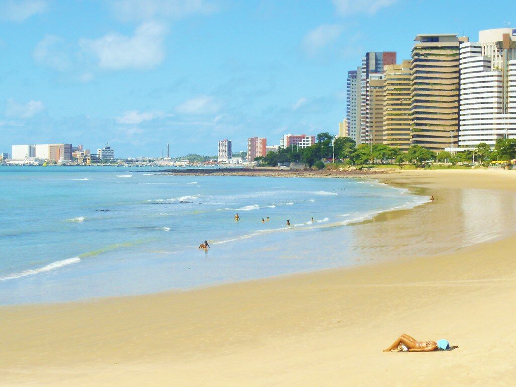 Praia urbana ensolarada com prédios
