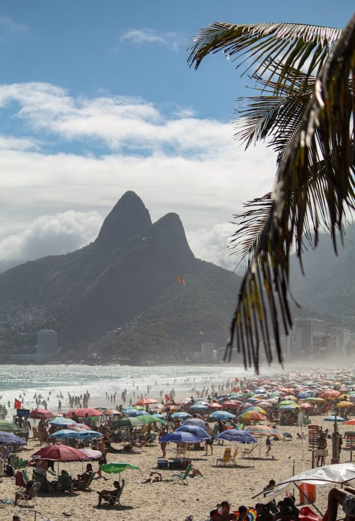 a crowded beach with a mountain in the background