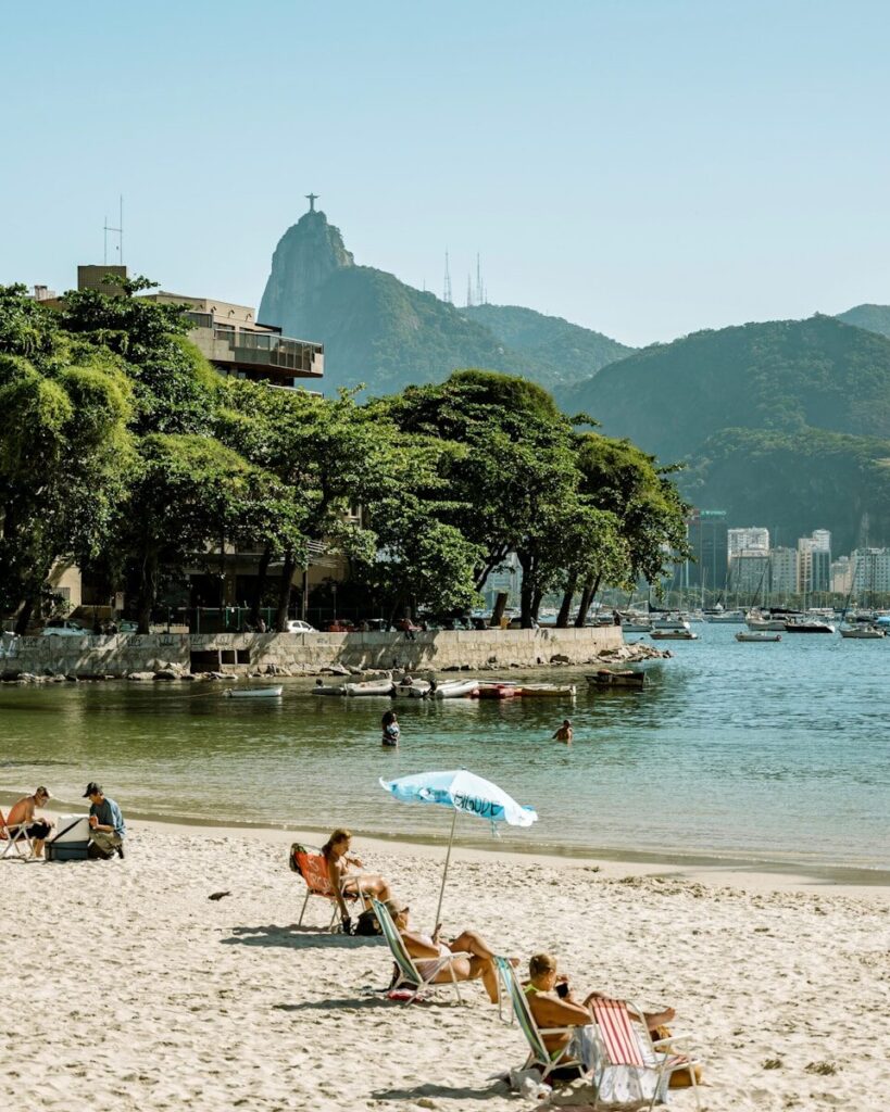 A group of people sitting on top of a sandy beach