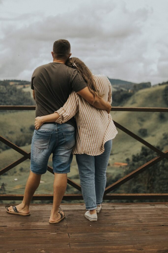 A man and a woman embracing on a bridge